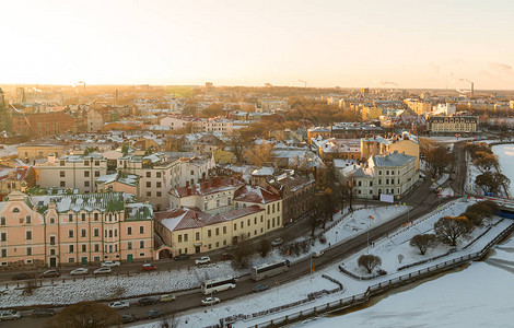 城市冬季从高处雪屋顶房屋和冰冻河流的Vyborg全景图片