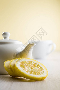 桌上有茶壶和杯子的柠檬片图片