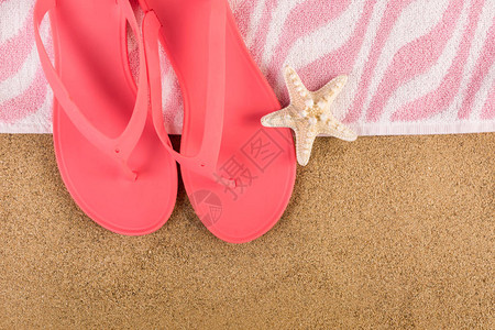 沙滩和海星上的粉色凉鞋拖和毛巾图片