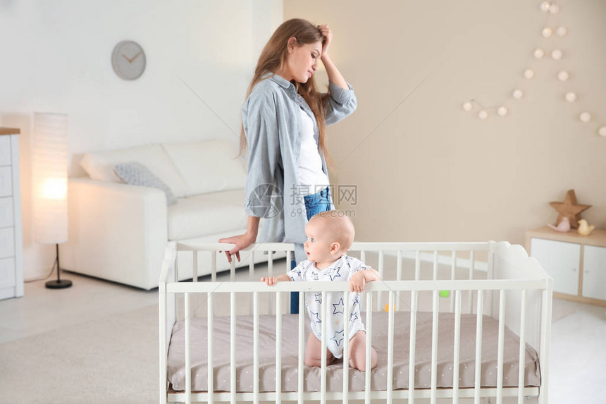 婴儿床的可爱女婴和在家患有产后抑郁图片