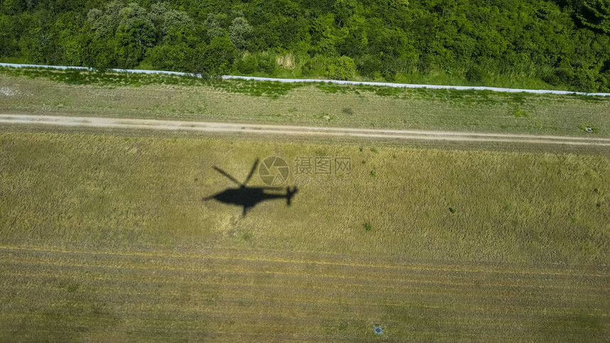 直升机飞越绿草的阴影图片