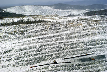 采掘挖土机和货运列车提炼铝土矿石的雪丘工作采石图片