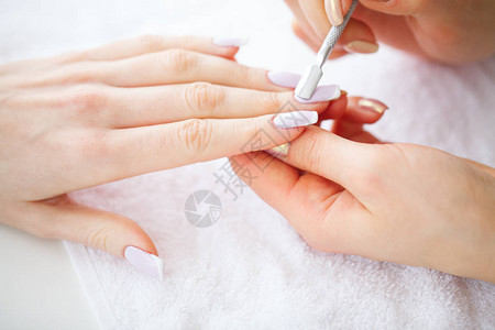 SPA修指甲水疗沙龙的法式美甲女人在美甲沙龙接受修指甲程序图片