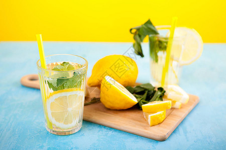 含黄底柠檬的美味有机脱毒水在蓝色图片
