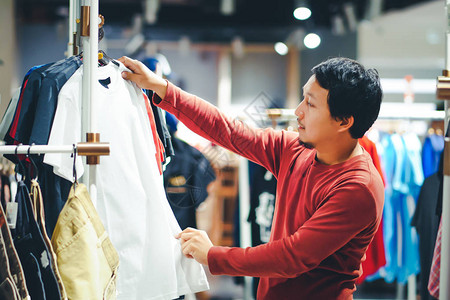 有胡子的聪明人在购物中心的服装店挑选衣服图片