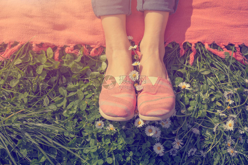 坐在绿色草地的粉红色花棚上的女人图片