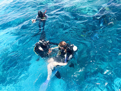 三名身穿黑色水肺潜水服的水下潜水员图片