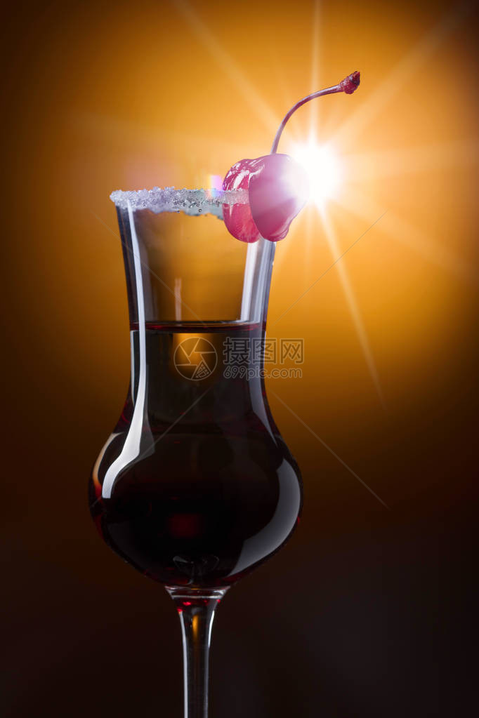 用樱桃和糖装饰的酒精分层鸡尾酒图片