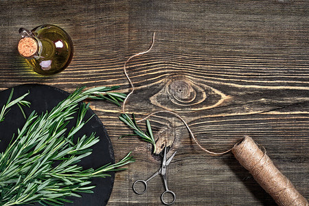 迷迭香的树枝在灰色的木桌上砧板上的迷迭香质朴的风格图片