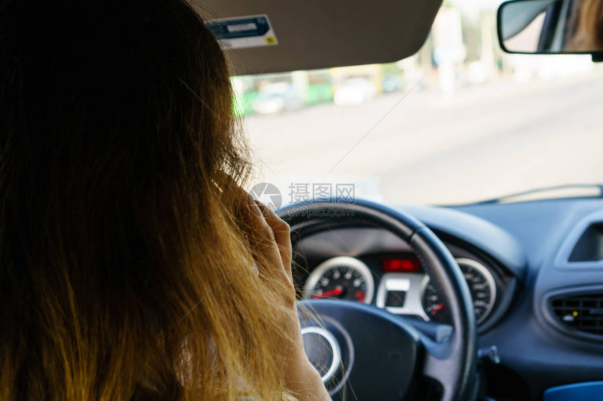 有选择地侧重于商业妇女驾驶汽车时用智能电话说图片