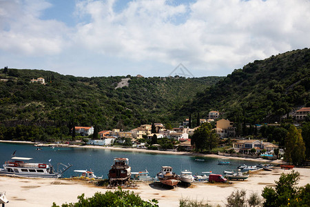 有停靠船只的传统渔镇有湖景的山村海岸线绿山的渔民湖社图片