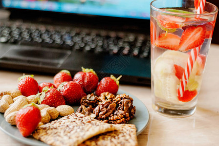 办公室员工有笔记本电脑健康零食草莓和黄瓜水图片