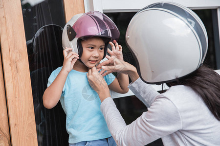 妈帮她女儿戴头盔骑摩托图片