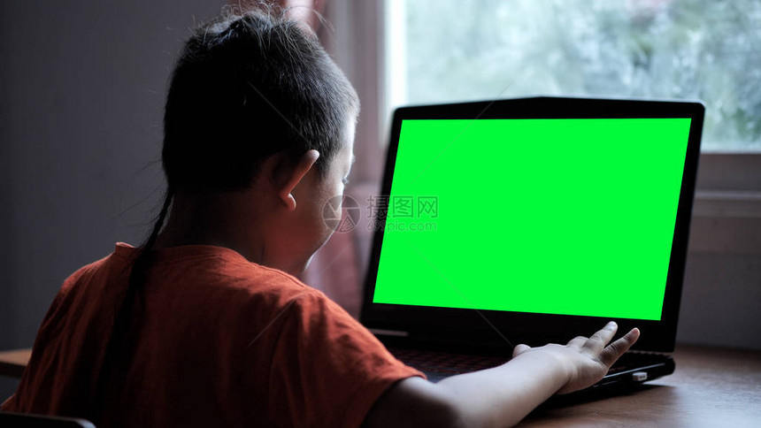 7岁的亚裔男孩在家中使用绿色屏幕搜索笔记本电脑搜索互联网信息日常生活中的图片