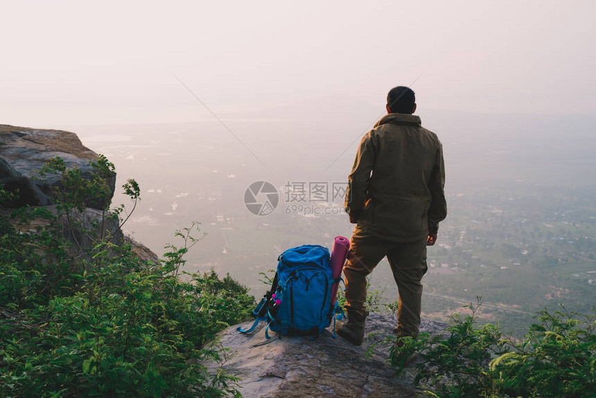 旅行者成功的年轻人站在山顶等待日出图片