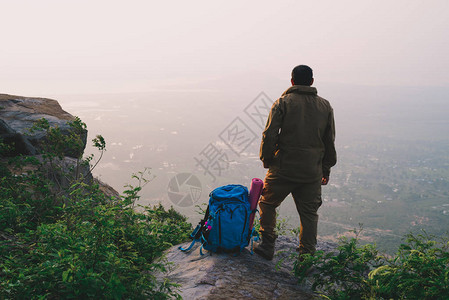 旅行者成功的年轻人站在山顶等待日出图片