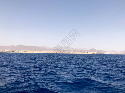 海岸上遥远美丽的棕色石山的海景和蓝盐黄海图片