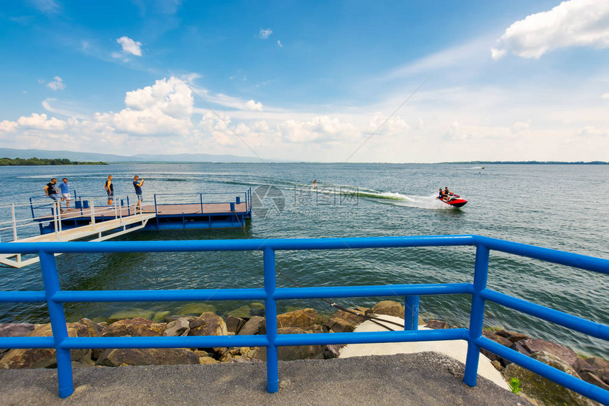 斯洛伐克ZemplinskaSirava湖上的蓝色码头夏季度假或周末的好去处人们在滑水和骑水上摩托车时玩得开心一些观察者或粉丝图片