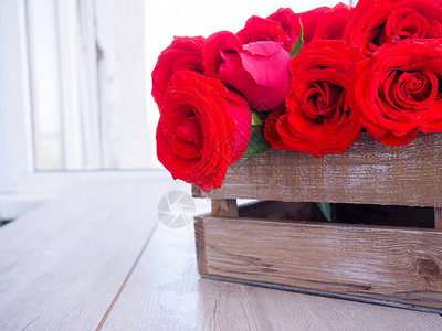 在木制背景的木箱中盛满一束玫瑰图片