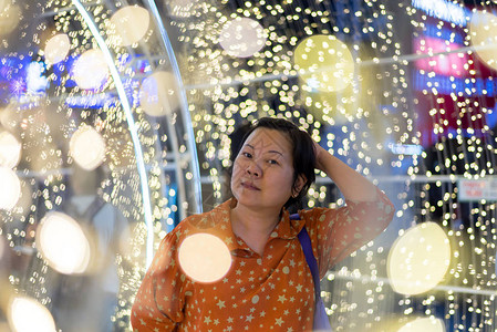 亚洲40多岁女人的时尚快乐地在夜间放松与光衣装饰一起为图片