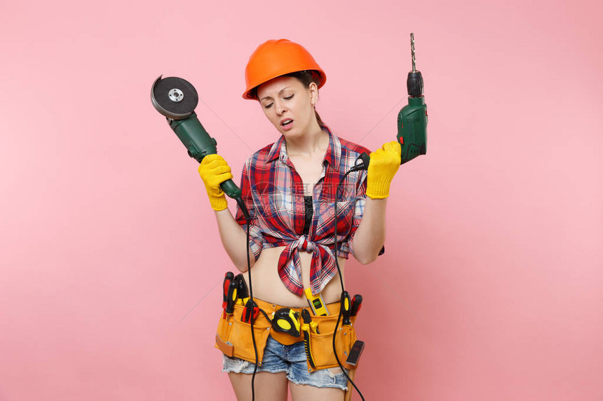 能源有趣的勤杂工女人戴着手套橙色防护头盔工具包工具带图片