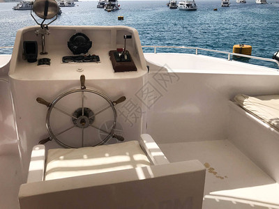 船长舱船带方向盘的游轮带海罗盘的仪表板和用于控制蓝色大海和天空图片