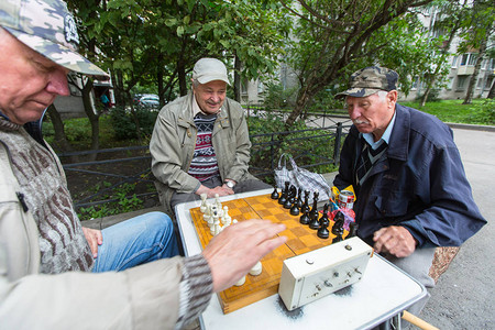 养老金领取者在一栋公寓楼的院子里下棋图片