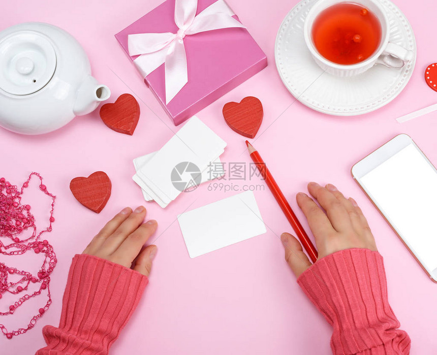 纸牌和红铅笔两只手旁边有粉红图片
