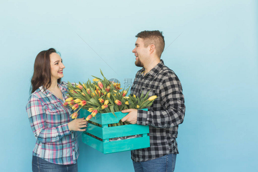 快乐的男女花店家拿着盒子带着郁金香图片