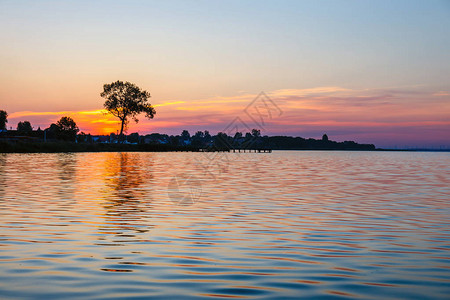 湖上的日出与背景中的树图片