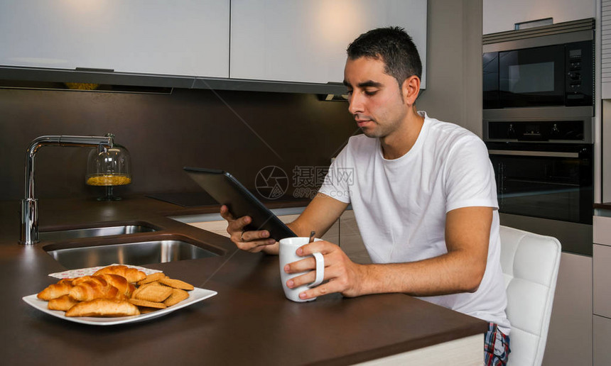 年轻人在厨房吃早餐看平图片