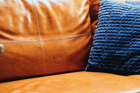 关闭真皮沙发上蓝色枕头的细节图片