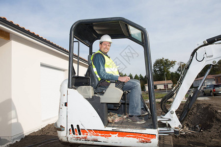坐在房屋建筑工地的buldozer挖土机图片