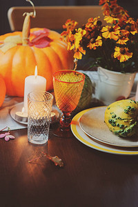 秋天感恩节或万圣节的传统桌位设置配有蜡图片