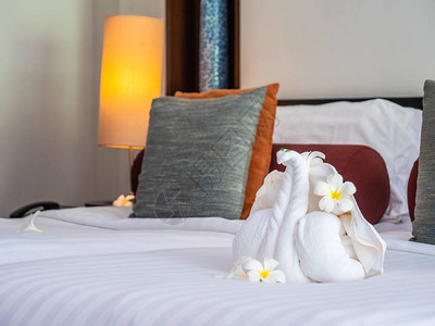 白色大象毛巾和舒适的枕头在旅馆卧室图片