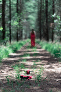 红鞋掉在森林的道路上背景图片