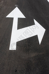 沥青上的两个白色箭头路牌下来交通图片