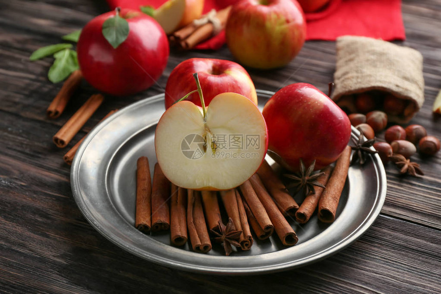 木桌上放着新鲜苹果和肉桂的盘子图片