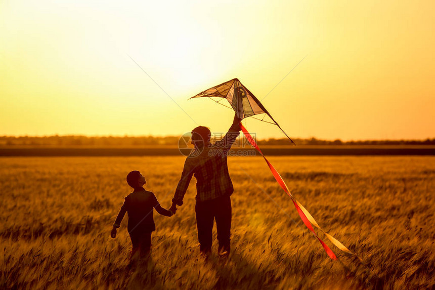 快乐的父亲和儿子在日落时图片