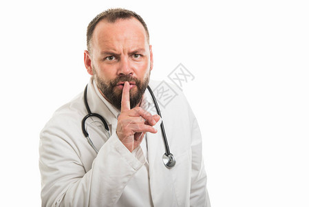 男医生在白色背景与复制空间广告区隔离时显示静默手势的肖像图片