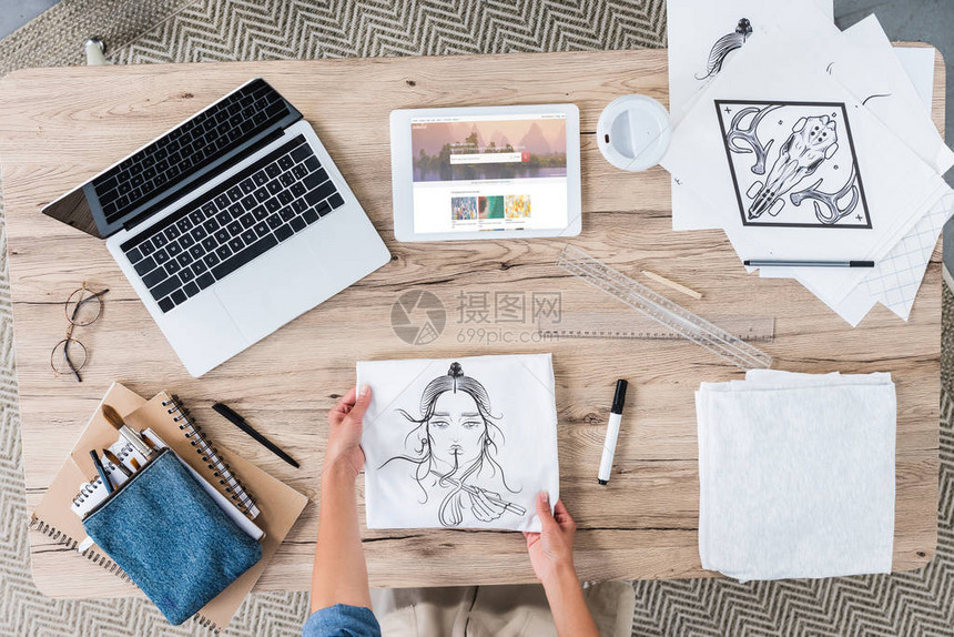 女设计者用笔记本电脑和数字平板电脑在桌上绘画以及屏幕图片