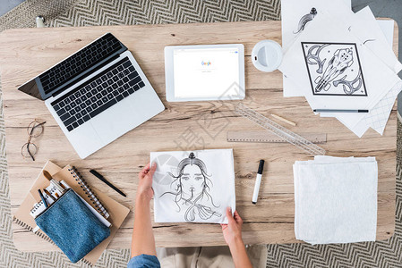 女艺术家用笔记本电脑和数字平板电脑在桌上绘画图片