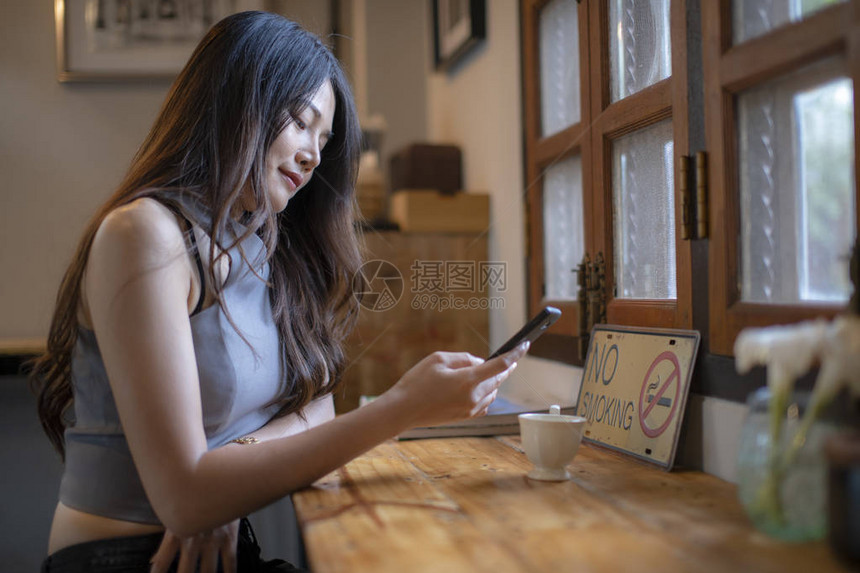 亚洲女在咖啡店查看手机信息图片