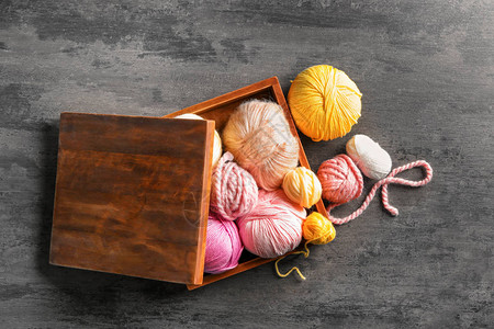 桌上有彩色针织纱的木盒图片