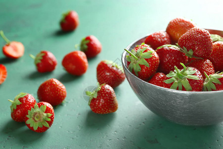 桌上放着甜熟草莓的碗图片