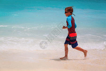 男孩跑在海滩上泼图片
