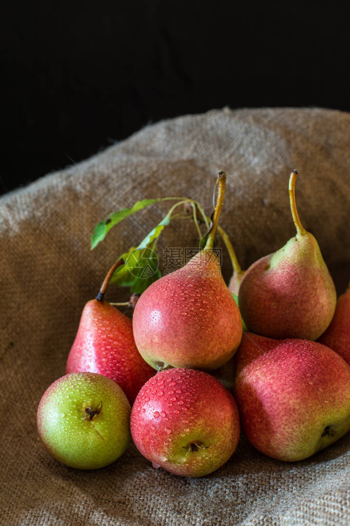 质朴的木桌上新鲜成熟的有机红梨图片
