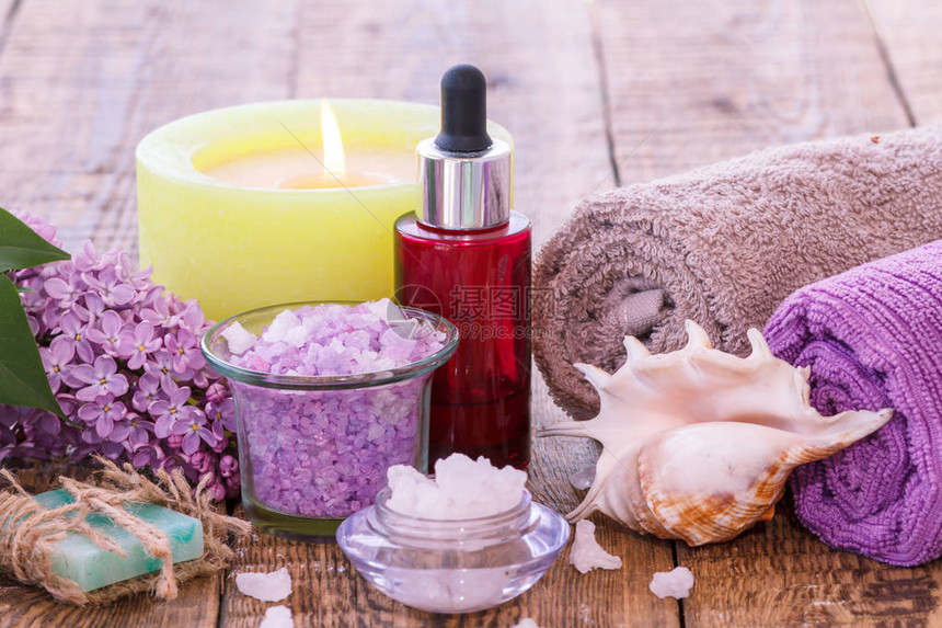 花粉肥皂烧蜡烛海盐碗香油红瓶海壳和木板上洗手间用的毛巾等图片