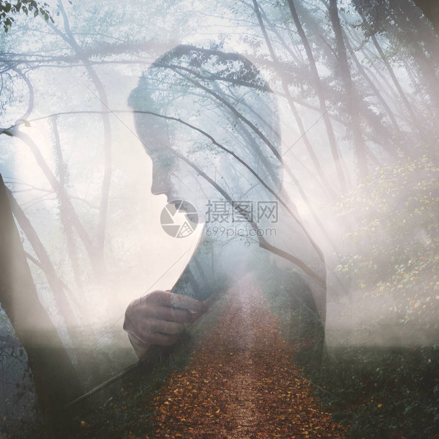 秋天年轻深思熟虑的女与雾林路的图片