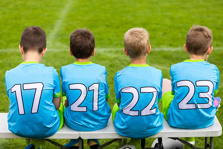 儿童足球比赛孩子们代替坐在板凳上的球员年轻男孩的足图片